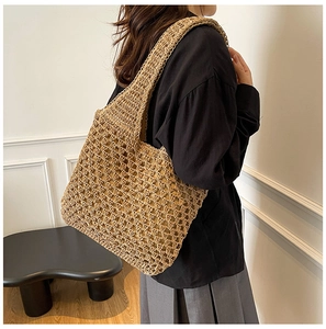 Close-up of a woven straw shoulder bag featuring a natural hollow mesh pattern and fabric lining