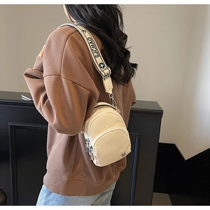 Détail du petit sac bandoulière crème avec fermetures éclair et large sangle imprimée