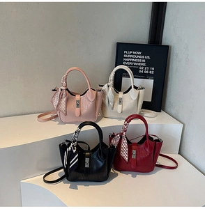 Detail of four stone patterned bucket bags with silk scarves and metal lock closures
