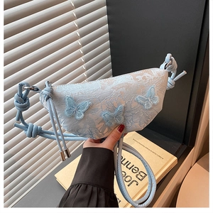 Detail der hellblauen Spitzenstickerei auf der Halbmondtasche mit 3D-Schmetterlingen