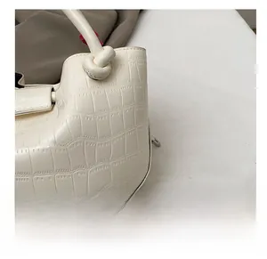 Detailed close-up of cream crocodile pattern PU leather bag featuring a unique knot handle