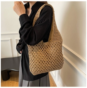 Detail of hollow mesh woven straw shoulder bag for summer beach vacation and daily use