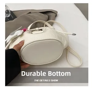 Detail view of the wear-resistant bottom and stone texture on the white bucket bag
