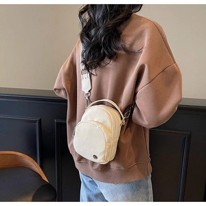 Détail d'un sac bandoulière blanc crème avec large sangle porté par un mannequin
