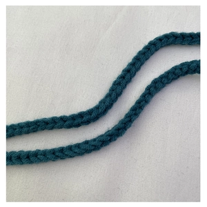 Detailed macro view of the dark teal hand-knit shoulder strap texture and weave pattern