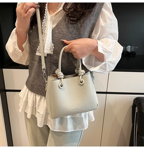 Detail of light mint green lychee grain leather bucket bag with knotted handle design