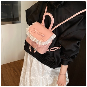 Detail of pink ballet-style backpack with lace trim and sweet bow accents on shiny PU