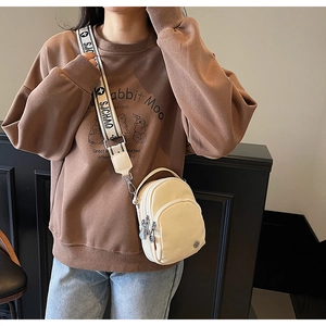 Détail d'un sac bandoulière crème en nylon avec large sangle en jacquard SJCHAO
