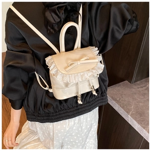 Detail of cream white mini backpack with lace trim and bow accent in ballet style
