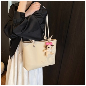 Detail of cream white lychee grain tote with thick rope handle and cute puppy charm