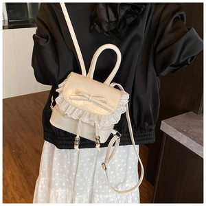 Close-up of cream PU leather backpack with delicate lace trim and ribbon bow detail