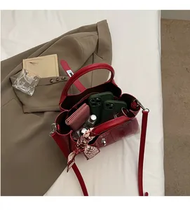 Detail of red crocodile pattern bucket bag showing spacious interior with personal items