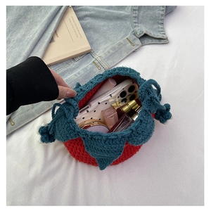 Top view of handmade strawberry knit pouch showing cosmetics and daily essentials storage