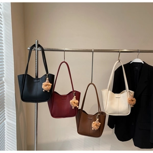 Minimalist U-shaped tote bags in four colors with plush charms and thin shoulder straps