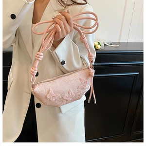 Detail der rosa Handtasche mit 3D-Schmetterlingsstickerei und elegantem Knotengurt