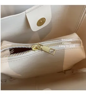 Detail of smooth gold zipper and magnetic closure inside the beige commuter bucket bag