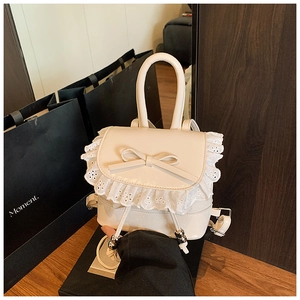 Detailed macro view of cream ballet-style backpack with lace trim and bow accent