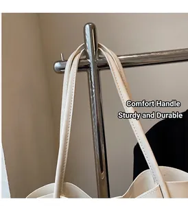 Detailed close-up of double-handle stitching and premium cream faux leather tote bag