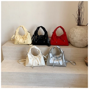 Bow knot hobo bags in five colors displayed on stone stairs with detachable straps