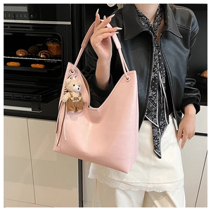 Pink glossy tote bag with a V-shaped top and a cute teddy bear charm on the side