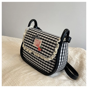 Detailed view of gingham canvas bag with lace trim, strawberry charm, and bow accent