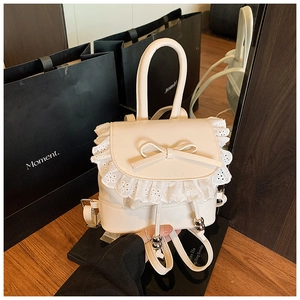 Detailed macro view of cream mini backpack with lace edges and delicate ribbon bow