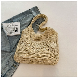Detailed view of the hollow-out flower crochet pattern on the woven beach shoulder bag