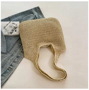 Detailed top view of beige woven straw tote bag with fabric lining and woven shoulder strap
