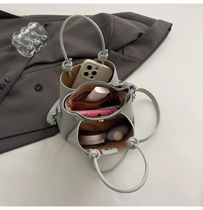 Spacious interior of mint green bucket bag showing phone and cosmetics organized neatly