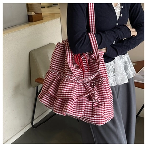 Detail of red and white checkered tote bag with tiered ruffles and drawstring closure