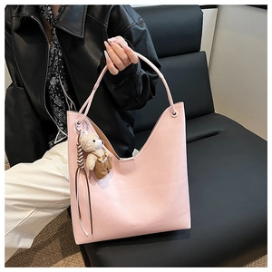 Pink faux leather tote bag with V-shaped cut, bear charm and stylish tassels detail