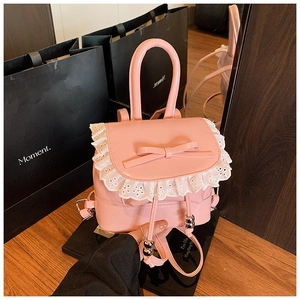 Close-up of pink mini backpack featuring white lace trim and PU material bow detail