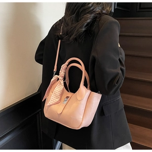 Pink faux leather bucket bag with crocodile texture and silk scarf handle on model