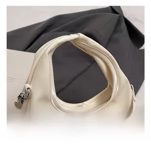 Detail showing the comfortable ruched handle and cream white faux leather of the hobo bag