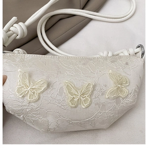 Detail der floralen Spitzenstickerei und 3D-Schmetterlingsapplikationen auf der Tasche
