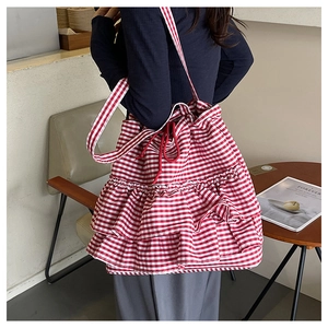 Detail of red gingham canvas tote bag with ruffle trim and drawstring closure