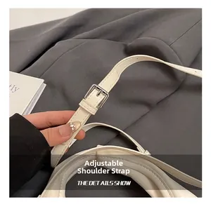 Close-up of adjustable white leather shoulder strap with a silver metal buckle