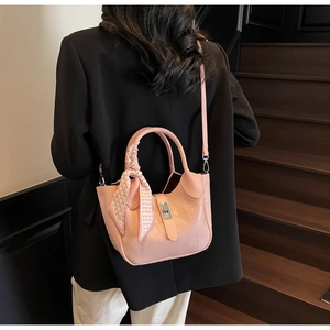 Pink embossed crocodile leather bucket bag with silk scarf detail on fashion model