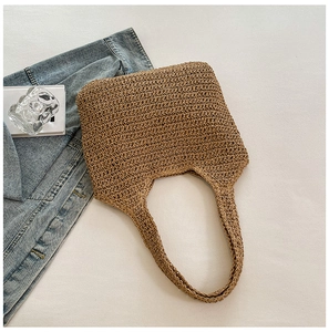 Top view of handmade straw tote bag with dense weave texture and wide shoulder straps