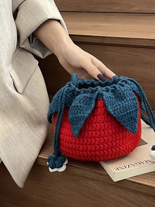 Handmade knitted tomato shaped drawstring shoulder bag with green leaf top and flower detail