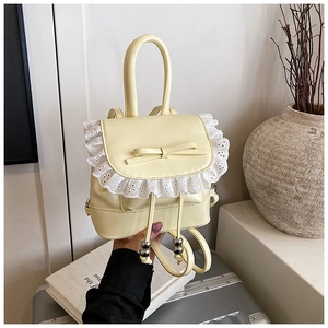 Close-up of cream yellow ballet-style mini backpack with lace trim and bow detail
