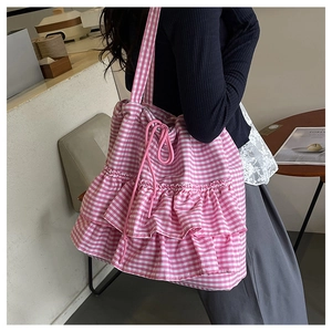 Detail of pink plaid tote bag featuring tiered ruffles and adjustable drawstring closure