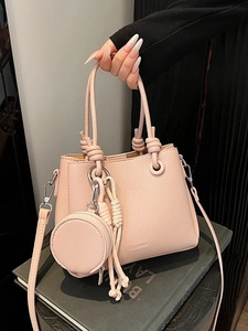 Pale pink lychee grain leather bucket bag with unique rope knot handle and round pouch