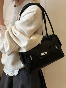 Minimalist black leather underarm bag with silver buckle and sleek vintage design