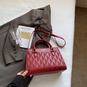 Dettaglio della borsa rossa strutturata con trama a rombi a rilievo e finiture dorate
