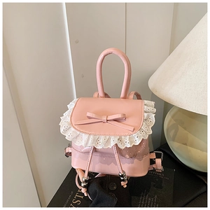 Close-up of pink shiny mini backpack with white lace trim and leather bow detail