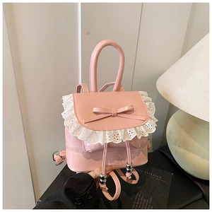 Close-up of pink glossy mini backpack with white lace trim and bow accent detail