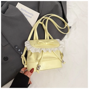 Close-up of pale yellow PU leather backpack with lace trim and bow knot detail
