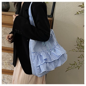 Detail of blue and white gingham tote bag with stylish three-tier ruffle design