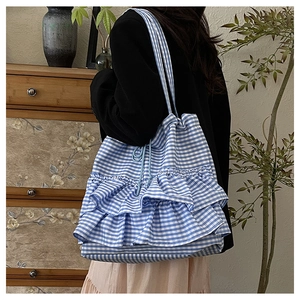 Close-up of blue gingham tote bag with triple ruffled layers and drawstring closure detail